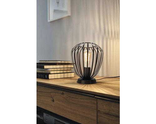 Dekorativ bordslampa med lampskärm av metallribbor och en glödlampa.