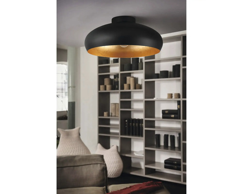 Svart taklampa med guldfärgad insida i ett vardagsrum