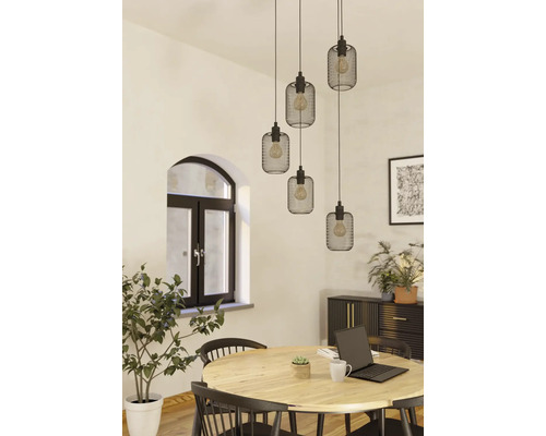 Matsal med träbord, stolar och en taklampa med flera svarta lampskärmar