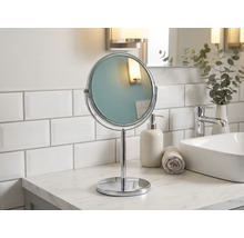 Fristående rund sminkspegel av metall i badrummet