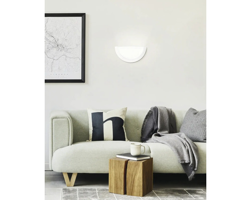 Vardagsrum med soffa, vägglampa och dekorativa föremål för en mysig atmosfär