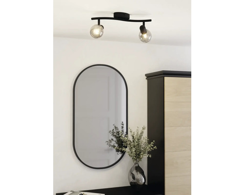 Taklampa med två spotlights och oval spegel ovanför byrå