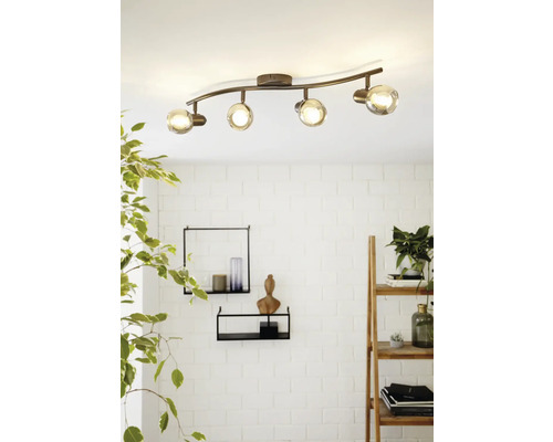 Taklampa med fyra spotlights och glasskärmar på en böjd stång.