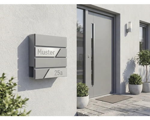 Modern brevlådesystem på en husvägg med inskriptionen Muster 25a