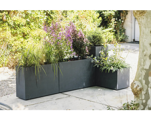 Planteringskärl i metall med olika växter utomhus