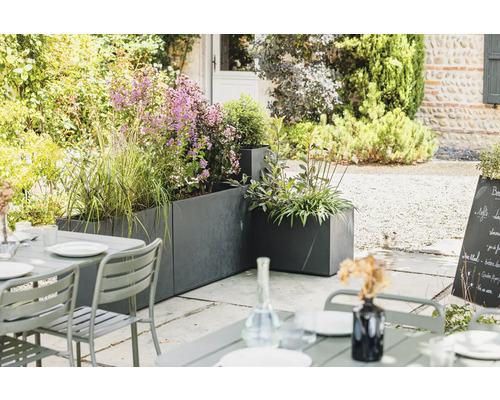 Uteplats med blomlådor och trädgårdsbord på terrassen