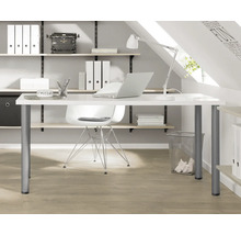 Ljust arbetsrum med skrivbord, kontorsstol, hyllor och kontorsmaterial.