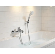 Badrum med badkar, armatur och handdusch framför väggplattor