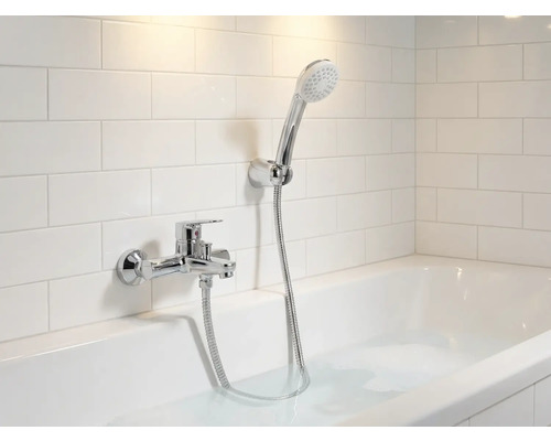 Badrum med badkar, armatur och handdusch framför väggplattor