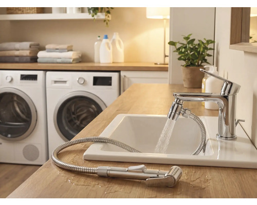 Ljust badrum med handfat, blandare med duschslang och tvättmaskiner