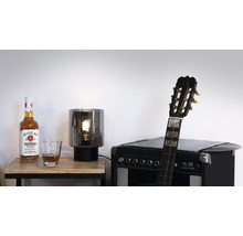 Dekorativ scen med flaska, glas, lampa och gitarr