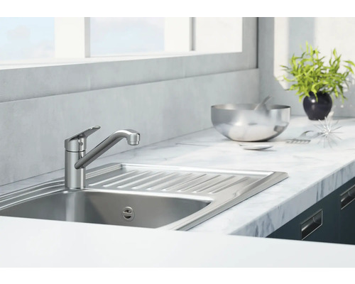 Blandare i metall i ett ljust kök med diskho