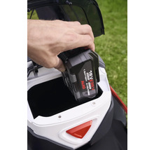 En hand sätter i ett Al-Ko 18 volt 36 volt batteri i en gräsklippare.