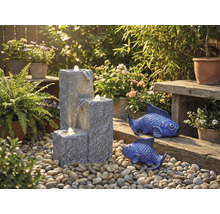 Trädgårdsscen med kaskadfontän, prydnadsfiskar och växter