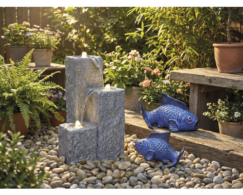 Trädgårdsscen med kaskadfontän, prydnadsfiskar och växter