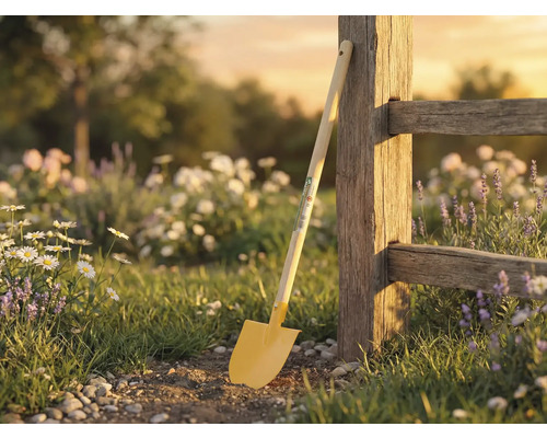 Trädgårdsscen med spade lutad mot trästaket