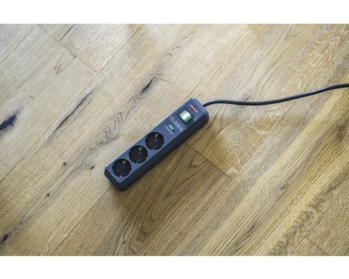 Grenuttag med tre uttag och överspänningsskydd på trägolv