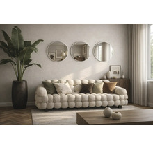 Vardagsrum med soffa, kuddar, runda speglar och krukväxt