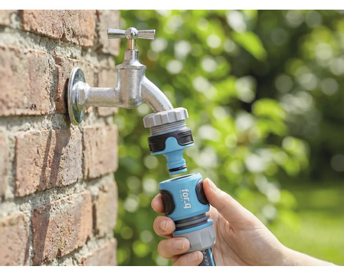 Trädgårdsscen med vattenkran, med for_q trädgårdsslangkoppling ansluten i handen