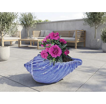 Dekorativiskålformad blomkruka med rosa blommor och trädgårdsmöbler i bakgrunden