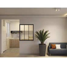 Vardagsrum med växt, soffa och passage till köket