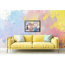 Gul soffa med kuddar framför en vägg med en inramad bild av en flicka och ett hjärta