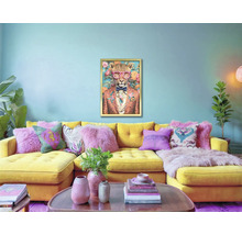 Vardagsrum med gul hörnsoffa, kuddar och en inramad leopardmålning på väggen