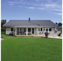 Modernt enplanshus med grå fasad, mörkt tegeltak, stor inglasad veranda och en välskött gräsmatta.