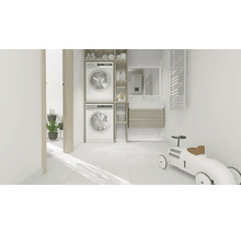 Ljust tvättrum med tvättmaskin, torktumlare och badrumsmöbler.