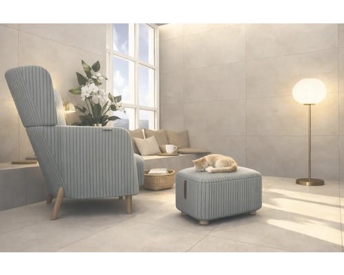 Vardagsrum med fåtölj, pall, golvlampa och en katt som sover på pallen