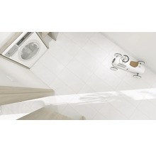 Tvättmaskin, vita plattor och en leksaksbil i badrummet