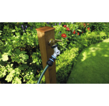 Trädgårdsscen med kran, trädgårdsslang och anslutning