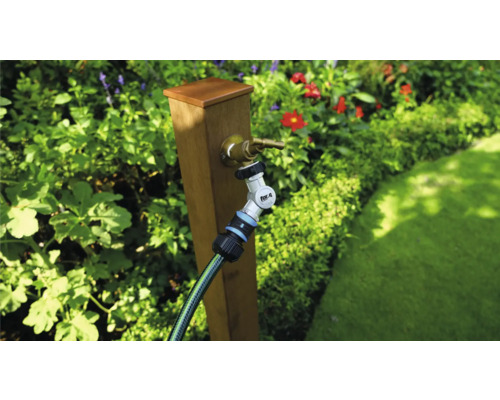 Trädgårdsscen med kran, trädgårdsslang och anslutning