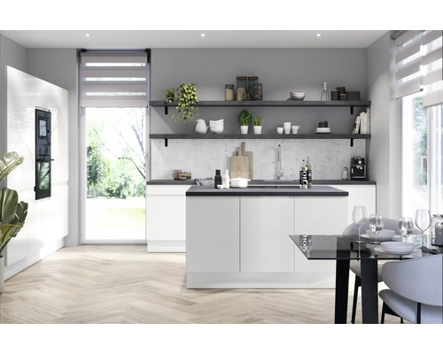 Ljust kök med köksö, hyllor och matbord i ett modernt vardagsrum.