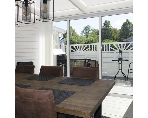 Ljus matplats med träbord, stolar i läderlook och skjutdörrar i glas mot en terrass med vitt staket.