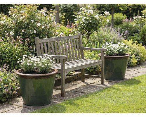 Trädgårdslandskap med träbänk och planterade blomlådor