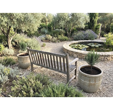 Trädgårdsscen med träbänk, planteringar och damm