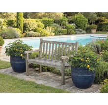 Trädgårdsscen med träbänk och blomkrukor bredvid en pool