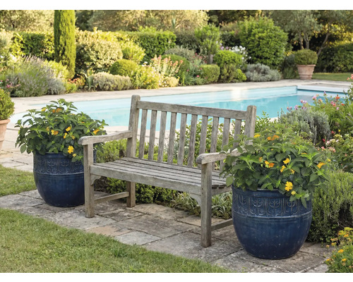 Trädgårdsscen med träbänk och blomkrukor bredvid en pool