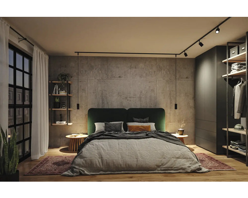 Modernt sovrum med vägg i betonglook, dubbelsäng med grön sänggavel och svart skensystem med spotlights och pendellampor.
