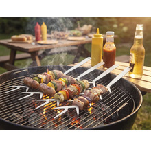 Grillscen med grillspett på en kolgrill, såser och drycker utomhus