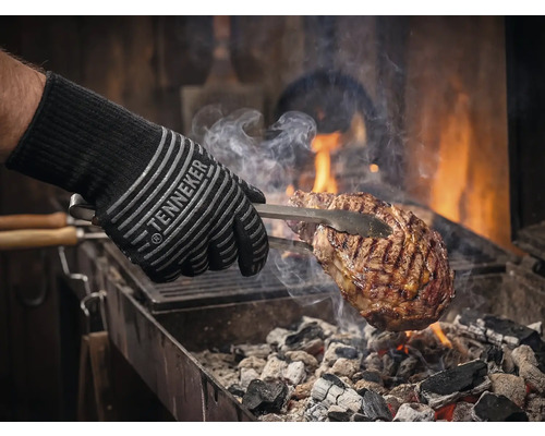 Grillhandske med kött på grillen