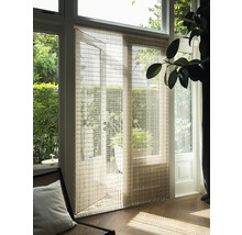 Interiörbild med panelgardin framför en altandörr, som försiktigt filtrerar dagsljuset