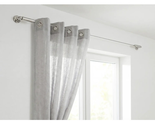 Gardin på gardinstång av rostfritt stål framför fönster