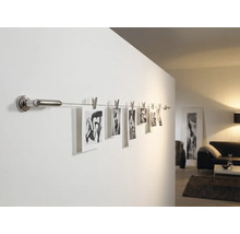 Foton på en väggskena med klämmor i vardagsrummet