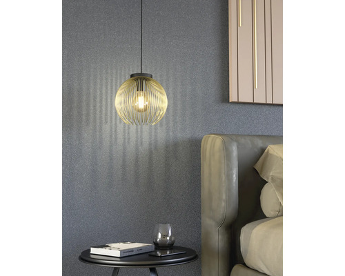 Scen med en gyllene hänglampa ovanför ett nattduksbord bredvid en säng.