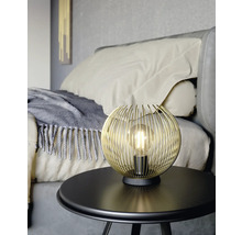 Gyllene trådkula lampa på ett bord i sovrummet