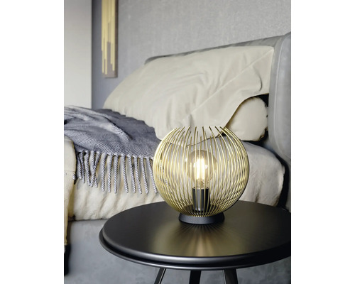 Gyllene trådkula lampa på ett bord i sovrummet