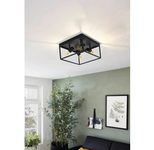 Svart taklampa med fyra lampor i ett vardagsrum