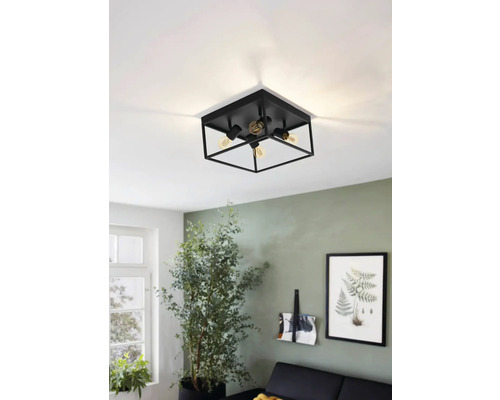 Svart taklampa med fyra lampor i ett vardagsrum